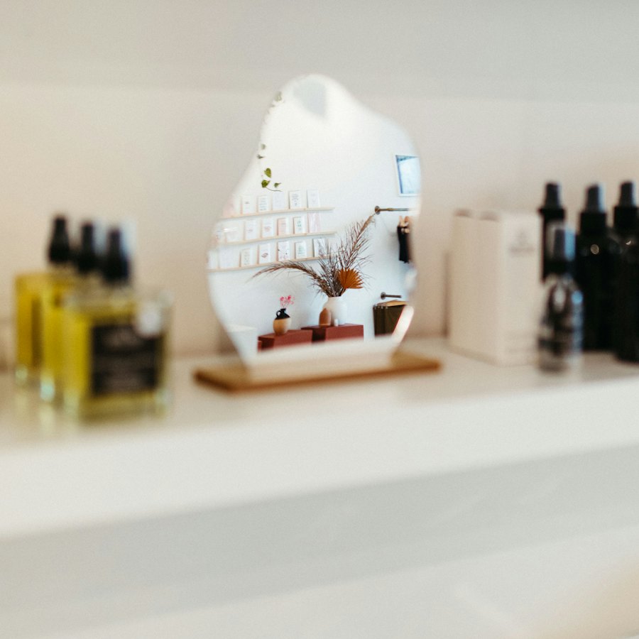 Un miroir et des produits sur une étagère blanche